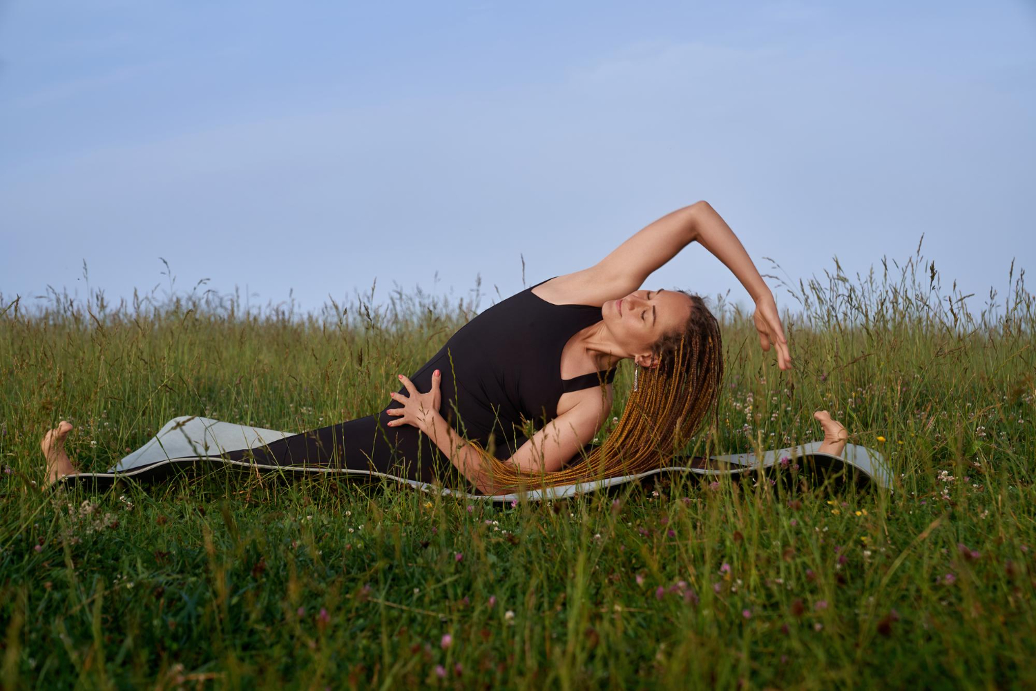 femme qui fait du yoga dans un champ