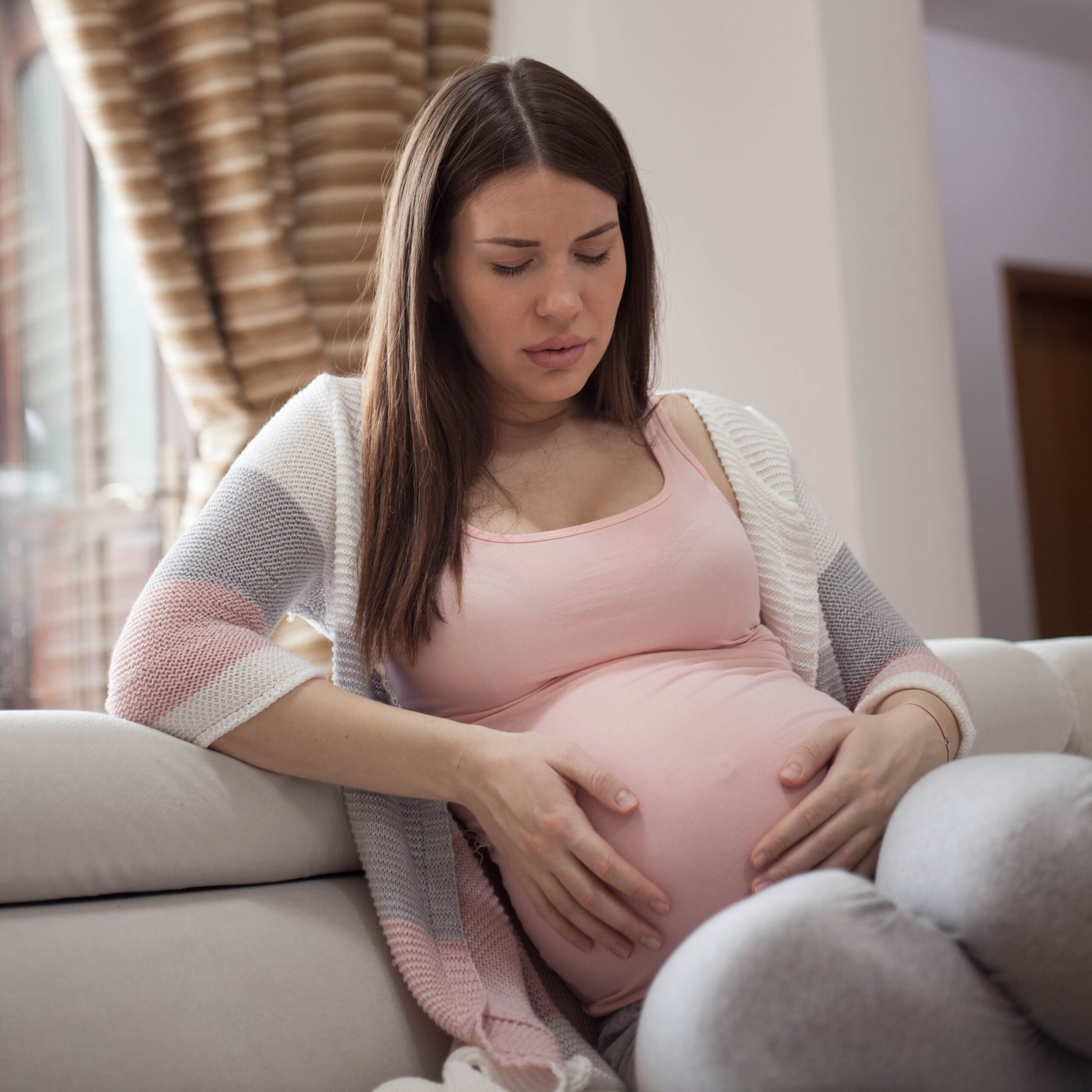 femme enceinte assise qui tient son ventre