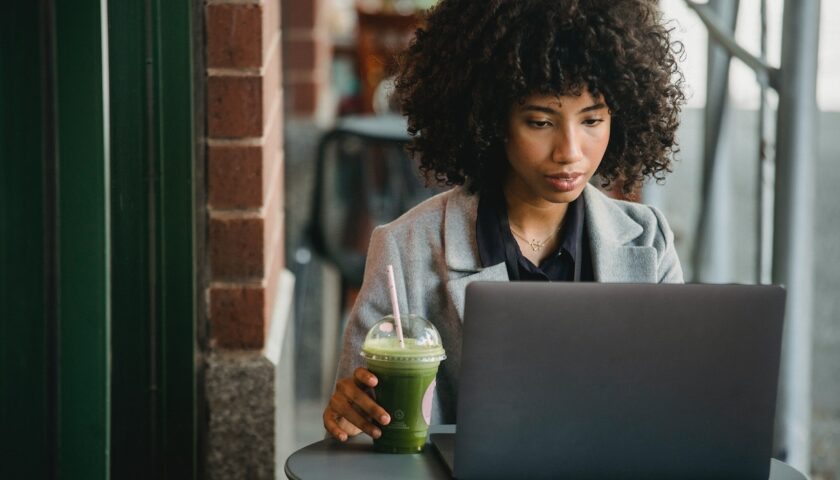 une femme noire travaillant devant son ordinateur