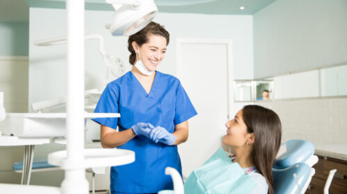 une femme orthodontiste dans son cabinet dentaire avec une patiente