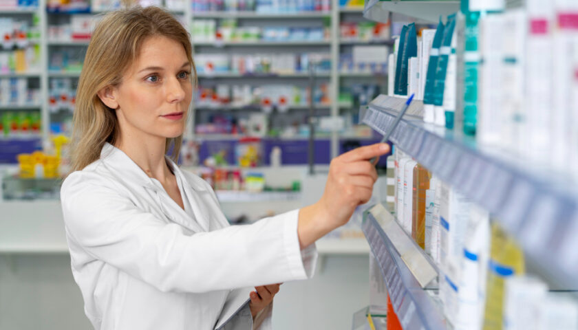 une secrétaire en pharmacie rengeant des médicaments